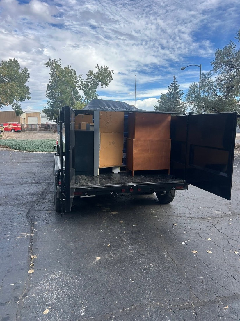 Furniture and cabinets loaded into a dump trailer