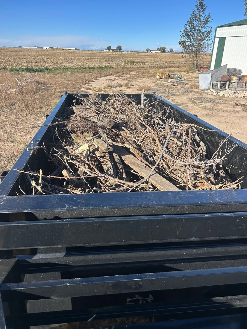 Dump trailer filled with branches and yard waste