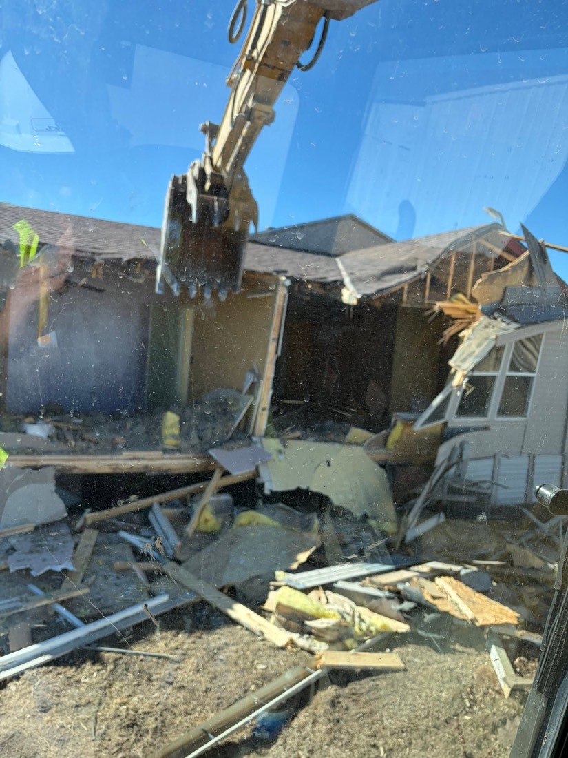 Heavy equipment removing a damaged structure