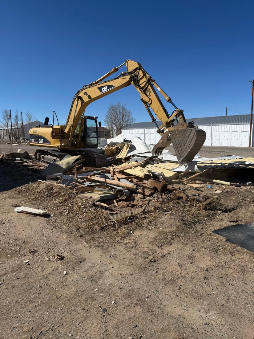 Excavator lifting debris during demolition